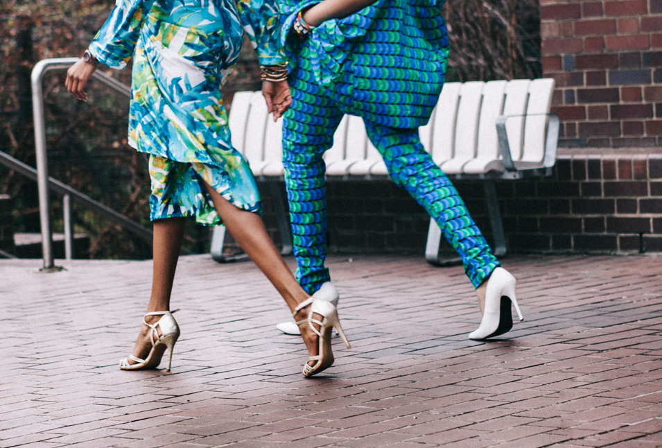 Two fashionable women walking along some cobblestones in gorgeous shoes